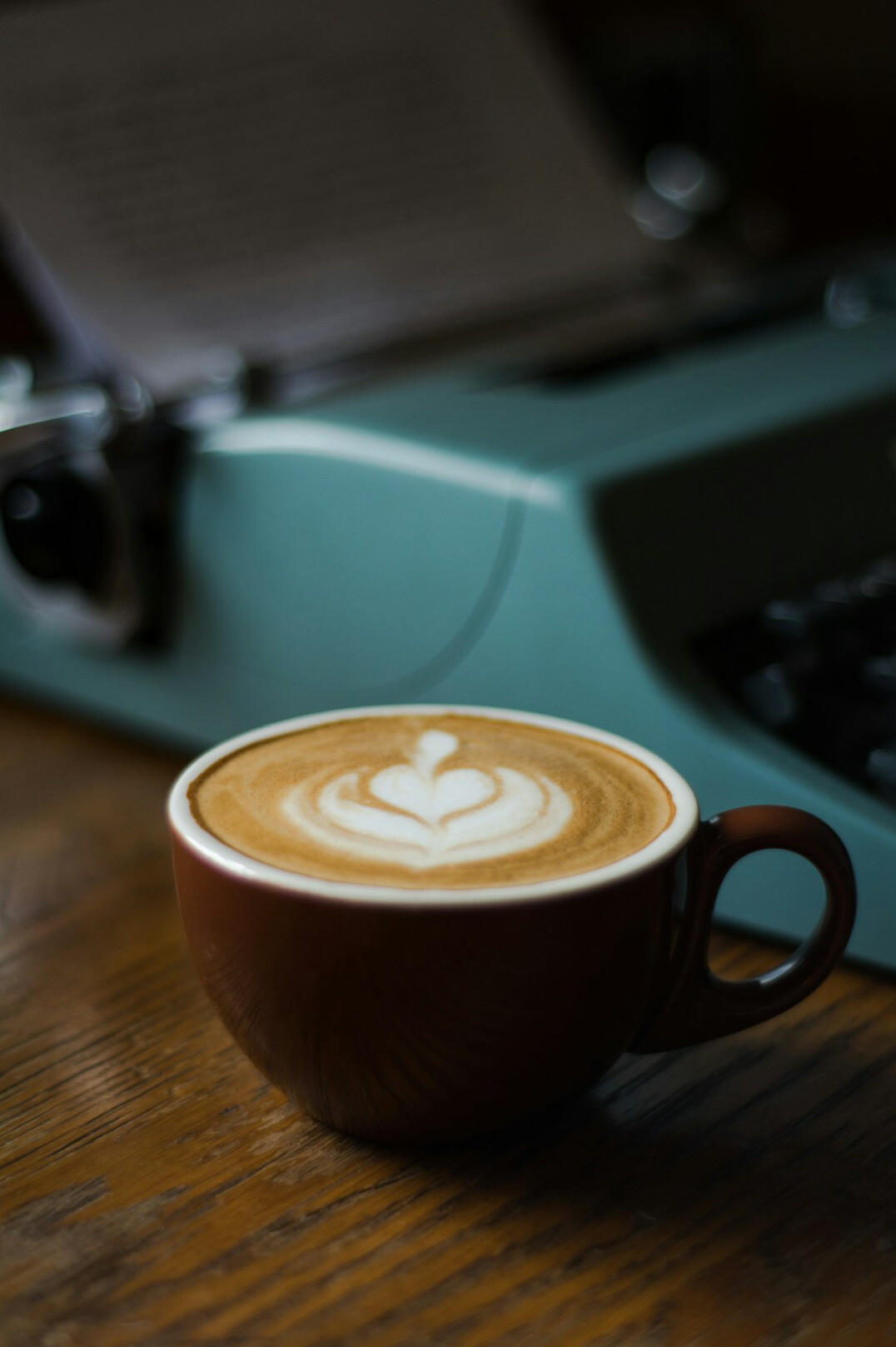 Vintage typewriter on a wooden desk with a cup of coffee