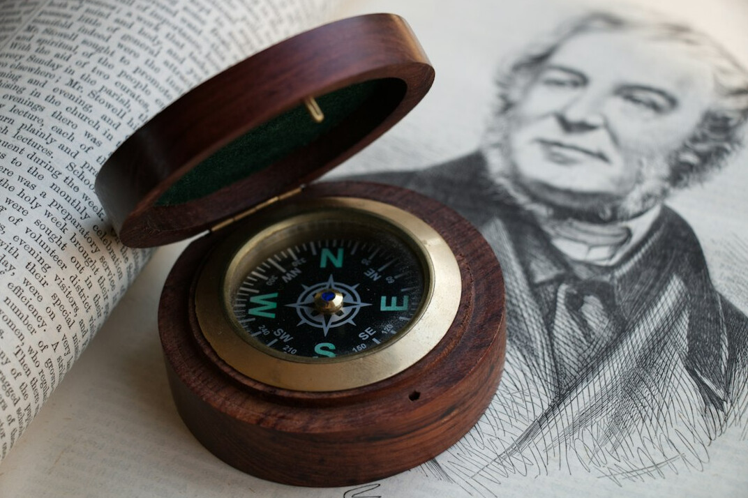 Antique map with a compass and magnifying glass on a wooden table